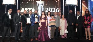 A group on stage with a trophy and certificate at the ARTA 2026 awards ceremony