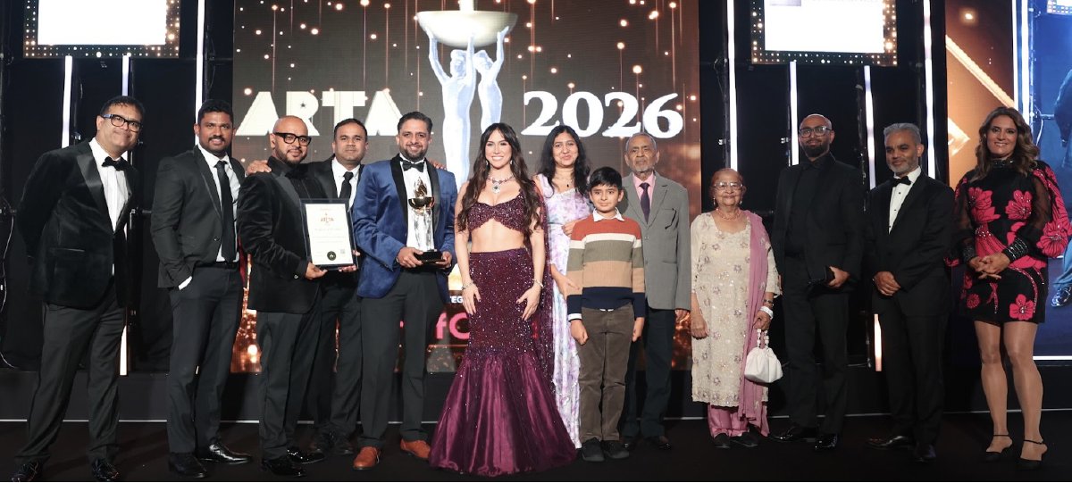 A group on stage with a trophy and certificate at the ARTA 2026 awards ceremony